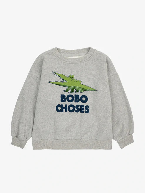 Unser Ziel ist es, Kinder dazu zu inspirieren, die Welt aus verschiedenen Perspektiven zu erkunden. Unser „Talking Crocodile“-Sweatshirt in einem sanften Grauton zeigt eine verspielte Zeichnung dieses Tieres mit weit geöffnetem Maul. Stellen Sie sich eine Geschichte vor, in der Krokodile, anstatt Piraten zu jagen, wissen, wie man Musik spielt und eine Party belebt.