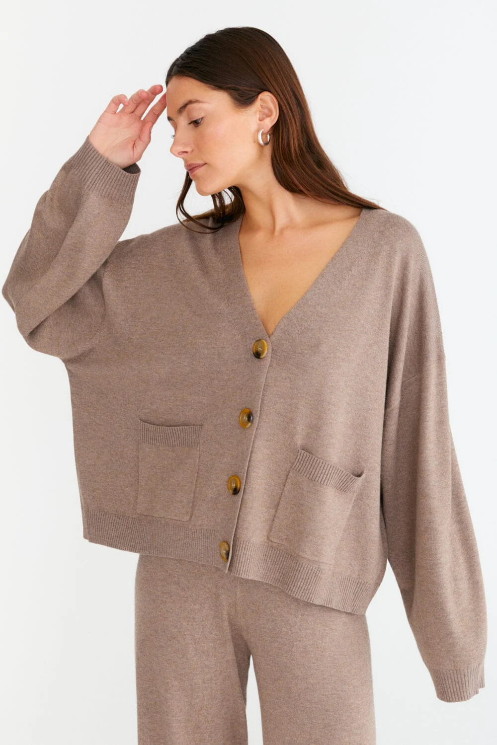 Eine klassische Strickjacke mit kastigem Strickmuster und Knöpfen auf der Vorderseite.
