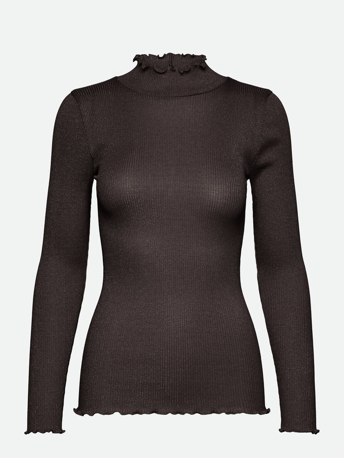 Diese Rollkragenbluse besticht durch ihre Raffinesse mit ihren gewellten Kanten an Halsausschnitt und Saum und verleiht jedem Outfit einen Hauch von Eleganz.