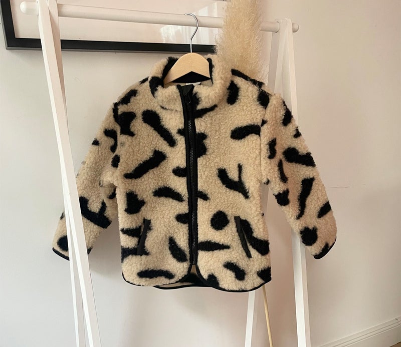 Die Jacke verfügt über Seitentaschen, wird mit einem Reißverschluss geschlossen und hat am Kragen Fleece Fütterung, damit es nicht kratzt. Unten ist der Abschluß rundlich. 