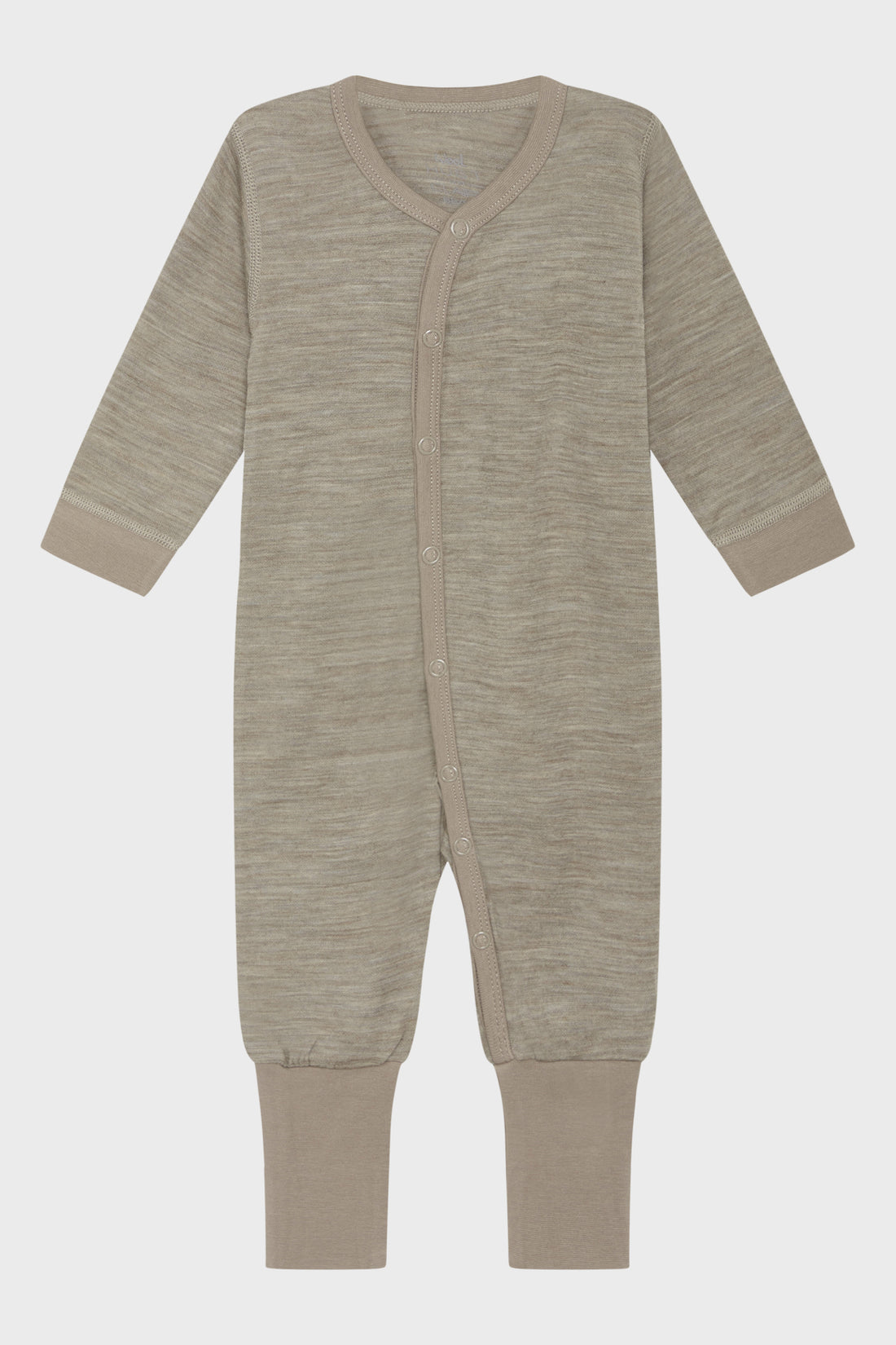 Langärmliger Overall aus bequemer, dehnbarer Merinowolle. Das Modell ist vom Hals bis zum linken Fuß leicht asymmetrisch geknöpft.